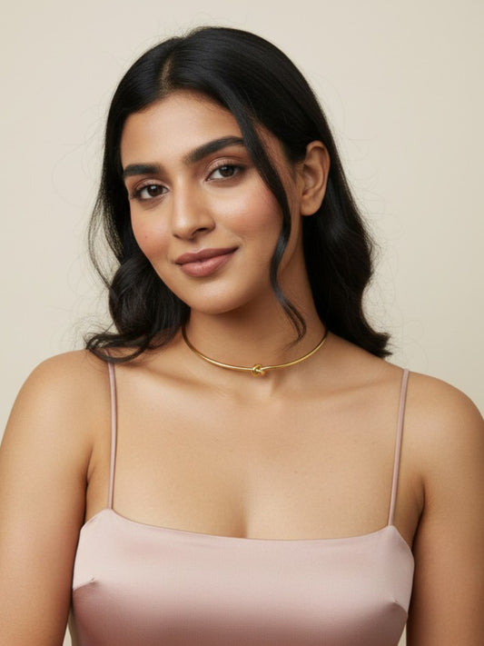 woman wearing 18k gold stainless steel knot choker with neutral background