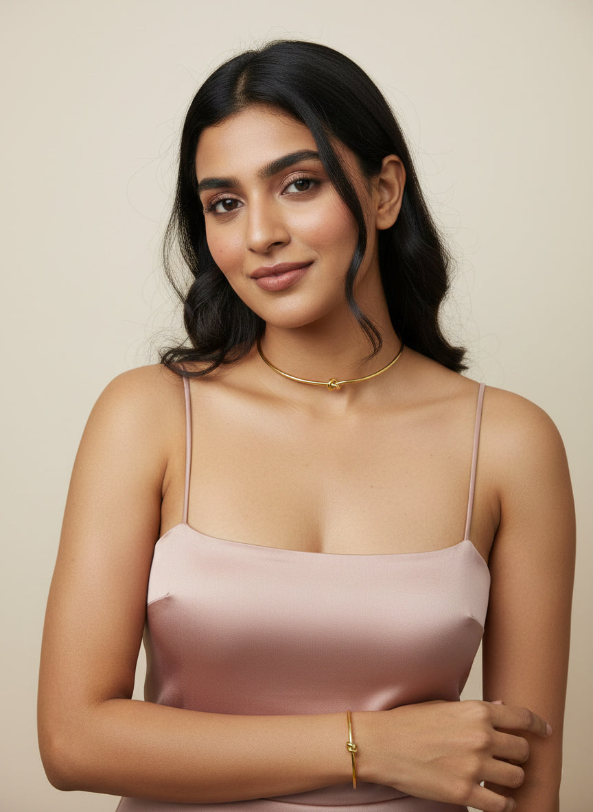 woman wearing set of stainless steel gold choker and bracelet with knot designs  