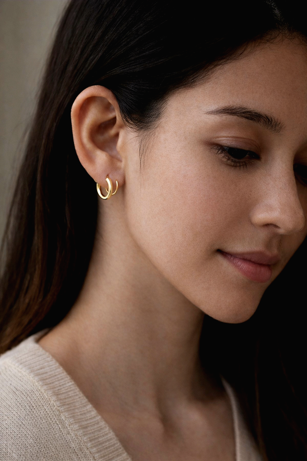 a woman wearing luxury stainless steel gold double hoop earring