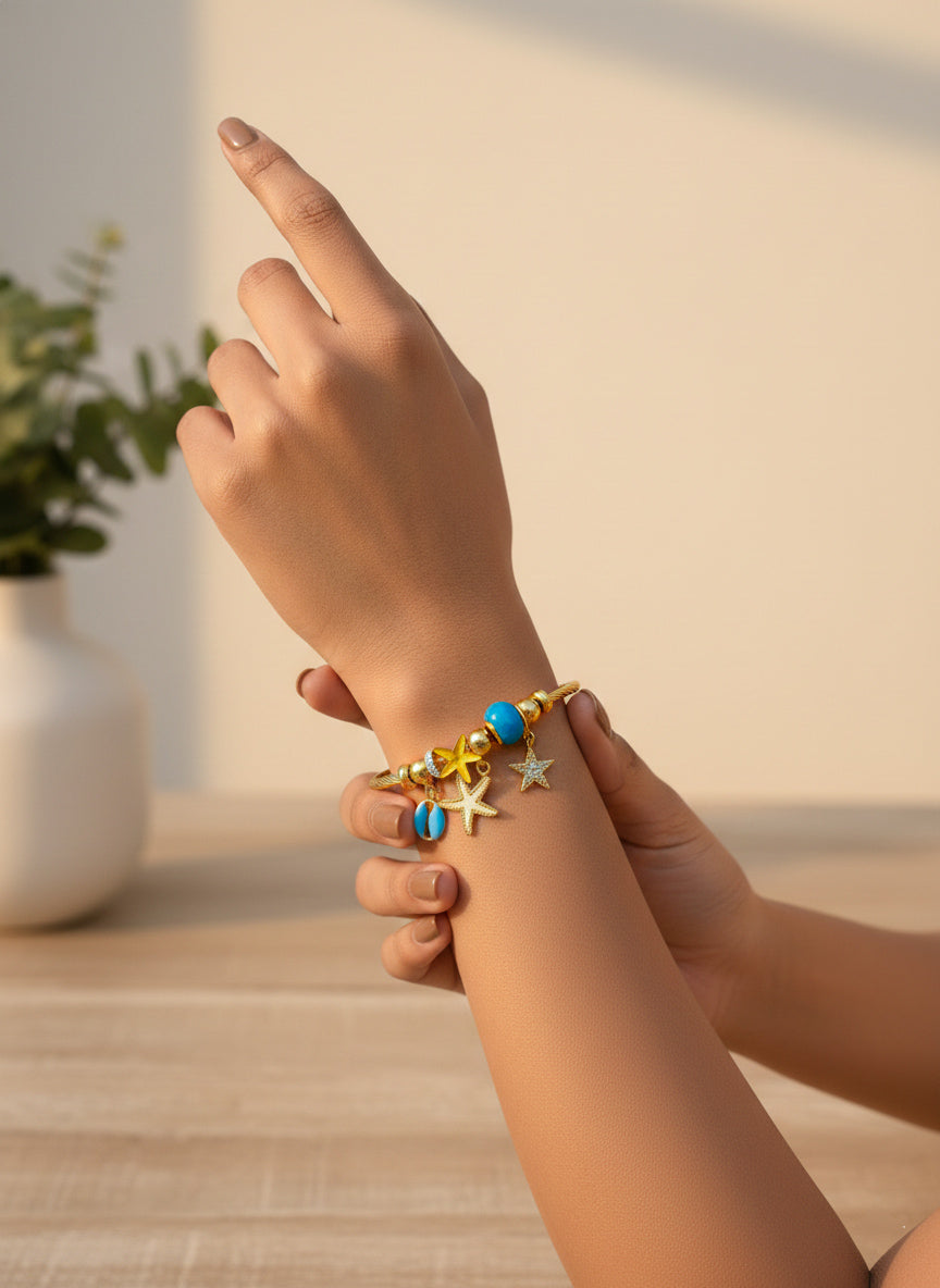 a stainless steel ocean theme star bracelet with colorful charms worn on hands with green plants in background